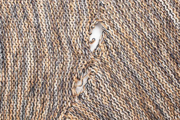 ripped pullover fabric that needs repair, repurposing concept, close up