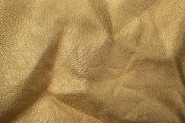 Animal skin, genuine leather texture painted with gold, abstract backdrop, soft focus close up