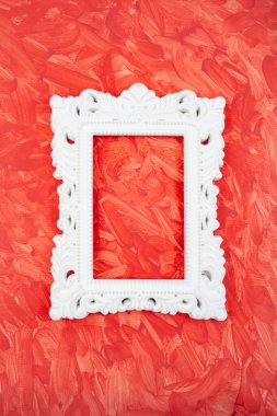 Kırmızı arkaplanda beyaz çimento barok çerçeve görünür fırça darbeleriyle, yakın çekim