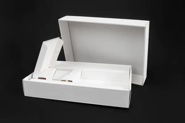 Empty smartphone or tablet box, white cardboard packaging isolated on black background