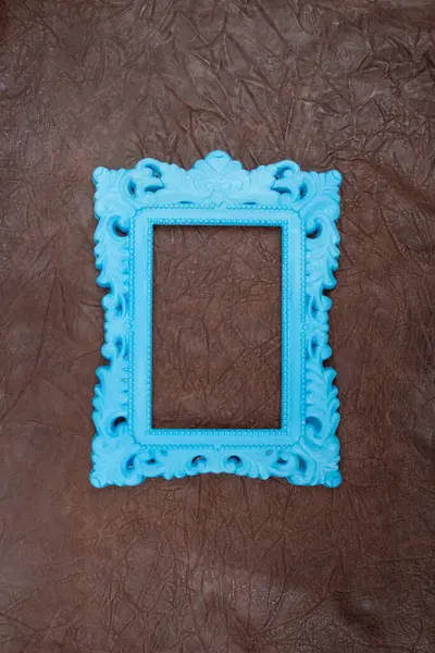 Empty blue painted baroque frame on genuine brown leather pattern, pop art style abstract backdrop