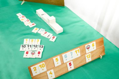 Türkiye 'deki rummikub, rummicub veya okey oyunundan plastik fayanslar ahşap bir rafa dizildi 