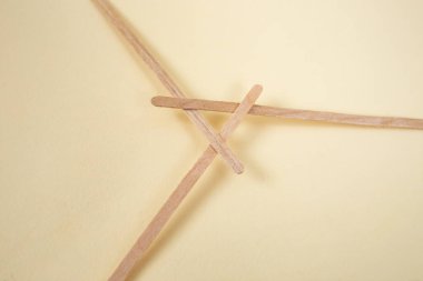 Bamboo wooden sticks demonstrating a reciprocal frame structure, on beige   clipart