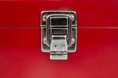 Kırmızı metal bir kutunun üzerinde paslanmaz çelik kilidi, kırmızı boyalı bir kutunun kapalı kapağı. 