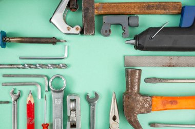 Boş kare kopyalama alanı ile yeşil arkaplan üzerinde düzenlenmiş çoklu el araçları 