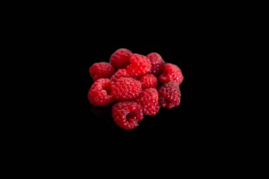 Ahududu meyvesi yığını siyah arkaplanda izole edilmiş, kapat