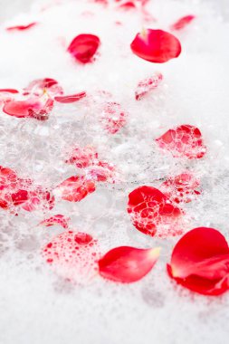 Kırmızı gül yapraklı beyaz banyo köpüğü, soyut kabarcık dokusu.  