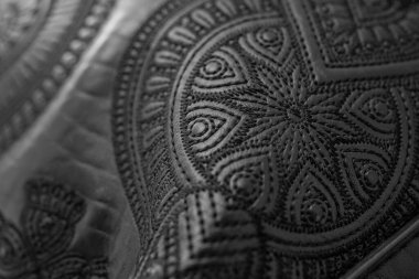 Yumuşak odak, siyah hakiki deri, soyut desenli detaylar üzerine iplik işleme çiçek tasarımı yakın detay  