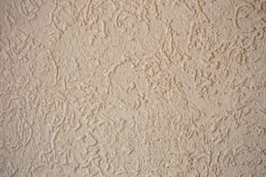 Soyut taneli sıva dokusu, evin dış duvarına bej boyalı çimento sıva. 