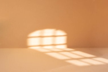 Güneş ışığı izli soyut bej oda arkaplanı, ürünün odaklı olmayan kağıdını göstermek için pencerenin gölgeli arkaplanı  