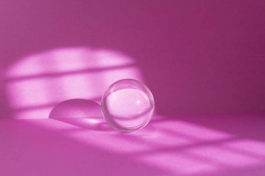 Abstract pink colored room background with window sun light trails and a glass sphere Backdrop with shadows of a window for product display defocused  clipart