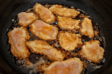 Tavuklu göğüs eti fileto tavada kaynamış yağda yumurta, düz yatıyordu. 