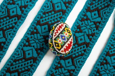 Romen boncuklu yumurtası ve mavi tekstil sınır çizgileri üzerine paskalya süslemesi 