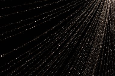 Noel süslemeleri gece gökyüzünü kaplayan çelenkleri aydınlatıyor.