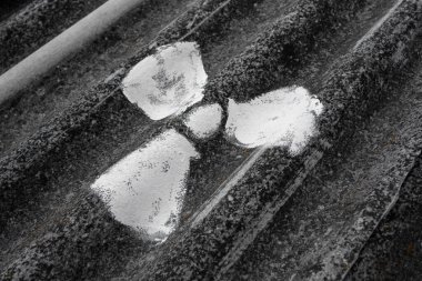 Yıpranmış asbest çarşafa beyaz boya sürülmüş radyoaktif sembol, soyut yumuşak odak  