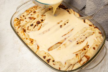 Peynirli krep turtasına ekşi krema sosu döküyorum.  