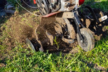 Tarla ekip biçmek için bahçe dümeni, toprağı gevşetiyor. El bilgisayarı motor sabanı hareket bulanıklığı ile toprak atıyor 