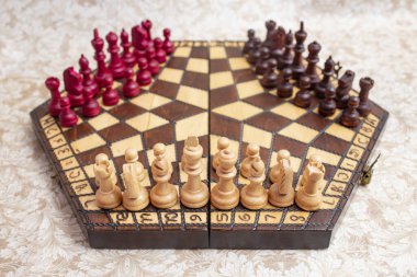 Altıgen tahta üzerinde siyah, beyaz ve kırmızı renkli üç satranç tahtası.