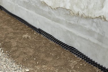 Bir evin zeminini geçirmez siyah folyoyla yalıtmak, yan görünüm 