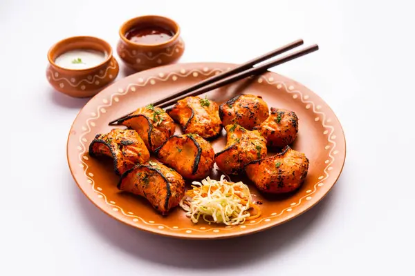 Tandoori momo, veg or non veg in red and cream sauce, served with sauce.  Nepal and Tibet recipe