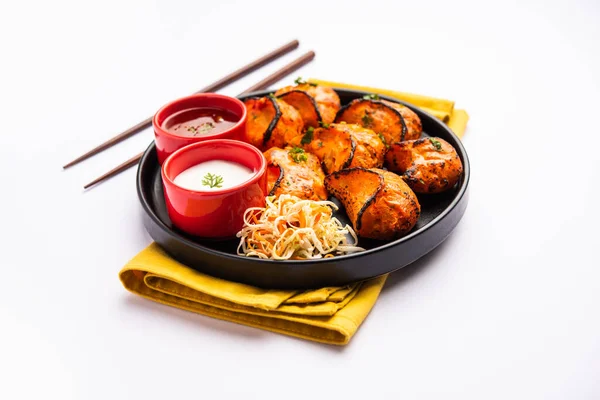 Tandoori momo, veg or non veg in red and cream sauce, served with sauce.  Nepal and Tibet recipe