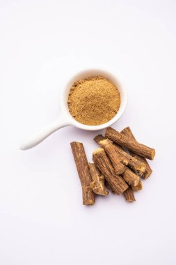 Ayurvedic Mulethi ya da meyan kökü kökü çubuğu ya da İsa tozu kasede servis edilen karamsar arka plan