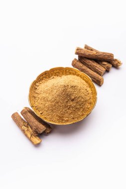 Ayurvedic Mulethi ya da meyan kökü kökü çubuğu ya da İsa tozu kasede servis edilen karamsar arka plan
