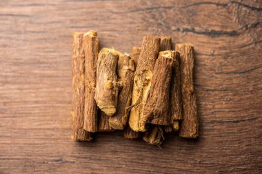 Ayurvedic Mulethi ya da meyan kökü kökü çubuğu ya da İsa tozu kasede servis edilen karamsar arka plan