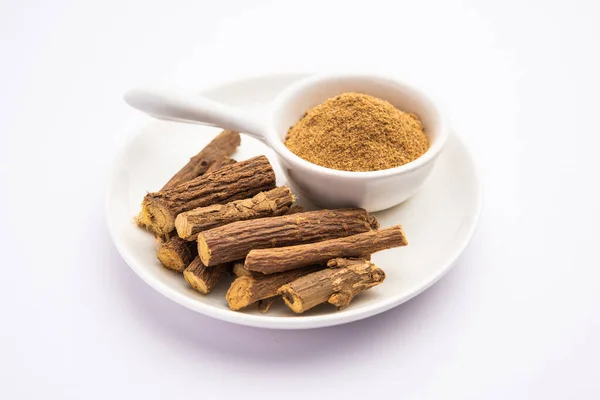 stock image Ayurvedic Mulethi or Liquorice root stick or jeshthamadh powder served in a bowl over moody background