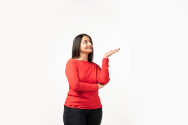 Beautiful mid age Asian woman pointing up to copy space and looking at camera with smile
