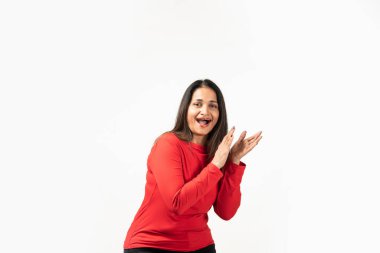 Happy attractive Indian woman laughing and smiling, applauding, clap hands and looking joyful