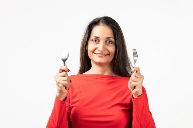 Indian thoughtful lady rising fork knife looking empty space isolated white color background