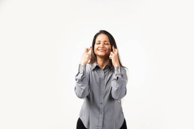 Indian mid age woman isolated on white background crossing fingers for having luck