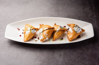 Hint tatlısı, hindistan cevizi, fındık ve meyvelerle dolu şeker şurubuna batırılmış kızarmış bir hamur işidir.