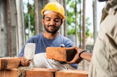 Tuğla duvar ören mutlu Hintli erkek inşaat işçisi - sıkı çalışma konsepti, el işçiliği