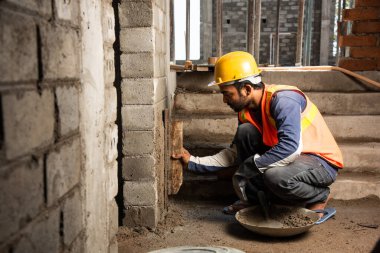 Tuğla duvar ören mutlu Hintli erkek inşaat işçisi - sıkı çalışma konsepti, el işçiliği