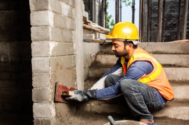 Tuğla duvar ören mutlu Hintli erkek inşaat işçisi - sıkı çalışma konsepti, el işçiliği