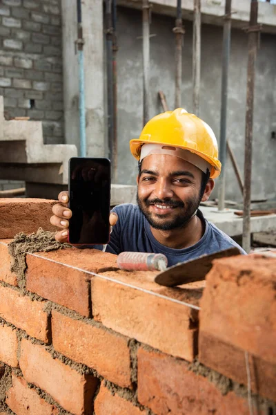 stock image indian construction worker or daily wage labour using mobile phone at site