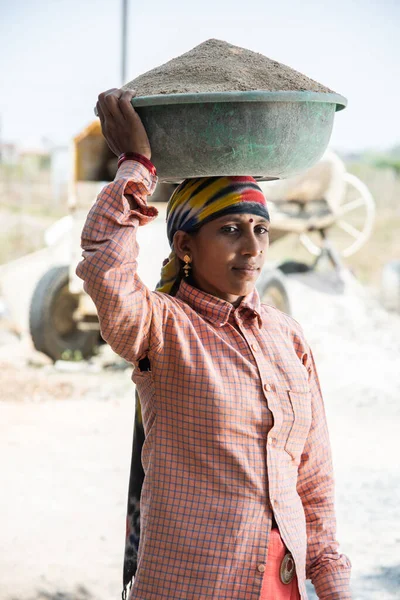 stock image Asian Indian woman labour or coolie working at construction site Carrying sand on her head.