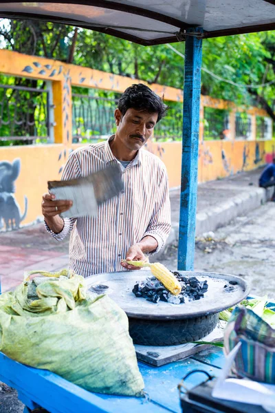 Indian street seller selling roasted corn or bhutta