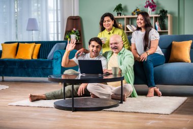 Neşeli Hintli aile evde bilgisayar kullanırken eğleniyor.