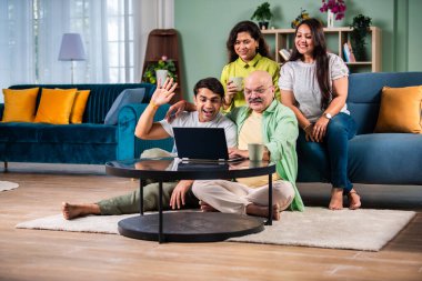 Neşeli Hintli aile evde bilgisayar kullanırken eğleniyor.