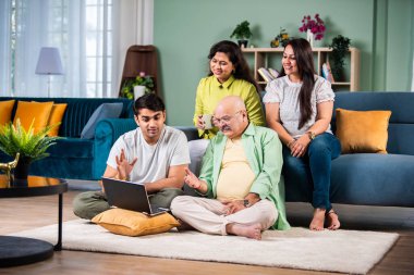 Neşeli Hintli aile evde bilgisayar kullanırken eğleniyor.