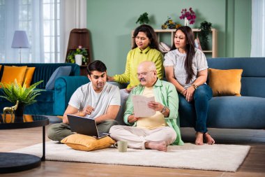 Neşeli Hintli aile evde bilgisayar kullanırken eğleniyor.