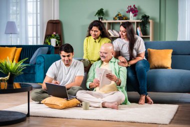 Neşeli Hintli aile evde bilgisayar kullanırken eğleniyor.