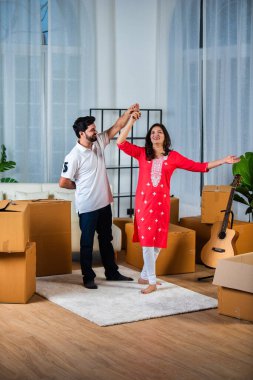 Evde dans eden Hintli genç çift oturma odasında taşınıyor ya da yer değiştiriyor.