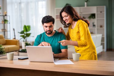 Mutlu genç Hintli evli çift masaya oturur giderleri hesaplar evde kolay internet bankacılığı hizmeti kullanır