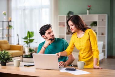 Mutlu genç Hintli evli çift masaya oturur giderleri hesaplar evde kolay internet bankacılığı hizmeti kullanır