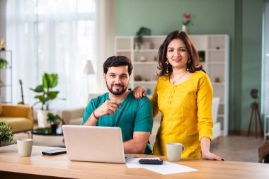 Mutlu genç Hintli evli çift masaya oturur giderleri hesaplar evde kolay internet bankacılığı hizmeti kullanır