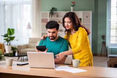Mutlu genç Hintli evli çift masaya oturur giderleri hesaplar evde kolay internet bankacılığı hizmeti kullanır